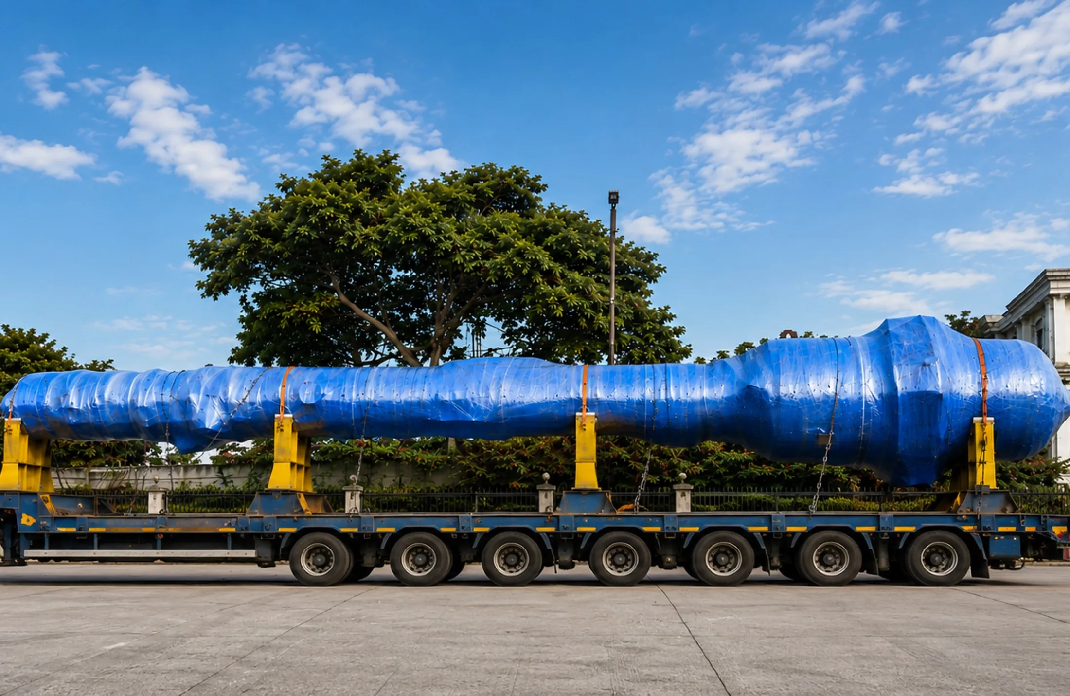 Blue-wrapped over-dimensional cargo secured for transport